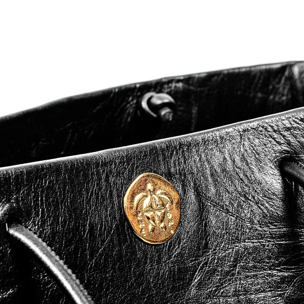 Closeup of Gabi Handbag | Made with creased cowhide leather and adorned with our solid brass Kheloni coin.