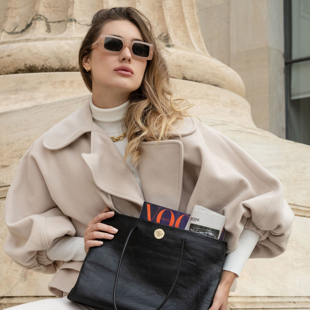 A Woman in Greece holding a Gabi Handbag | Made with creased cowhide leather and adorned with our solid brass Kheloni coin.